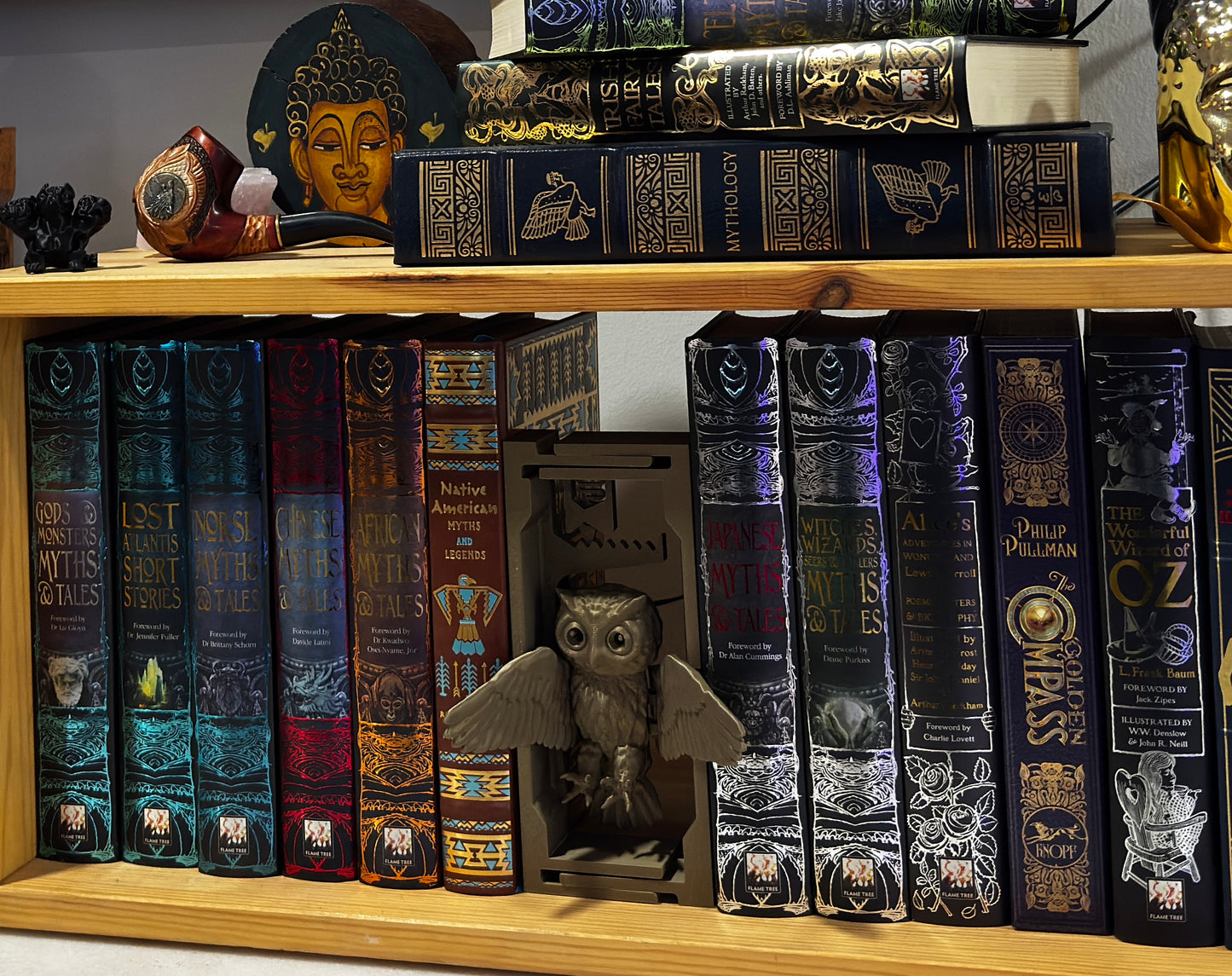 3D-printed adjustable owl book nook filling a gap on a wooden bookshelf.